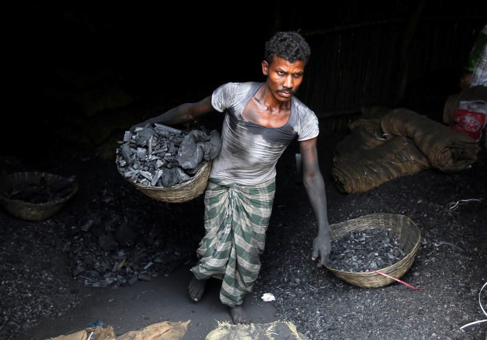 A worker carries coal in Mumbai, India