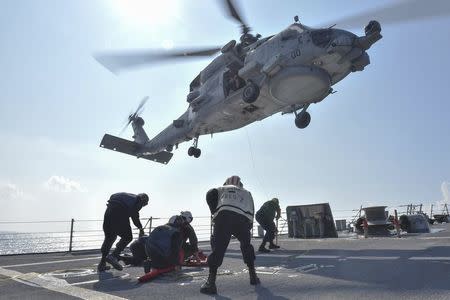 U.S. Navy Sailors participate in a medical training exercise on the deck of the Arleigh Burke-class guided missile destroyer USS Lassen (DDG 82) with an MH-60R Seahawk helicopter, in the South China Sea, October 28, 2015, provided by the U.S. Navy. REUTERS/U.S. Navy/Mass Communication Specialist 2nd Class Corey T. Jones/Handout via Reuters