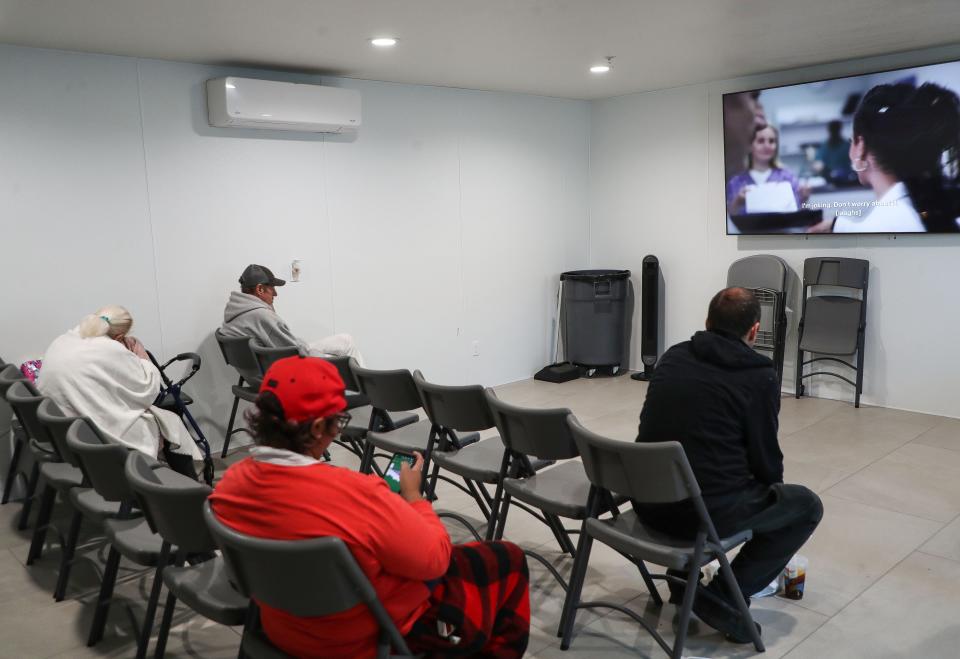 People watch tv and spend time out of the elements at the homeless access hub in Desert Hot Springs on Dec. 15, 2023.