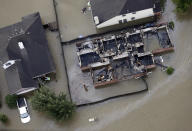 <p>A burned out home is surrounded by floodwaters from Tropical Storm Harvey on Tuesday, Aug. 29, 2017, in Spring, Texas. (Photo: David J. Phillip/AP) </p>