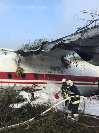 Members of emergency services work at the site of the Antonov-12 cargo airplane emergency landing in Lviv region