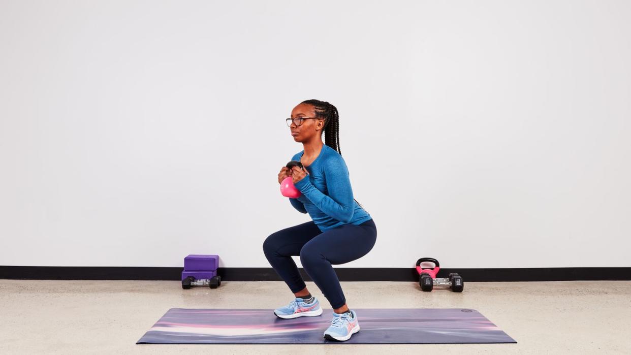 monique lebrun performing a kettlebell squat as part of the transverse abdominis set of exercises