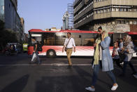 People cross Jomhouri-e-Eslami (Islamic Republic) St. in downtown Tehran, Iran, Monday, July 30, 2018. Iran's currency plummeted to a record low Monday, a week before the United States restores sanctions lifted under the unraveling nuclear deal, giving rise to fears of prolonged economic suffering and further civil unrest. (AP Photo/Vahid Salemi)