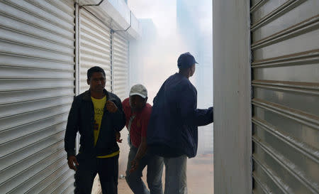 Madagascar opposition demonstrators protesting against new electoral laws attempt to shield from teargas fired by riot police in Antananarivo, Madagascar April 21, 2018. REUTERS/Clarel Faniry Rasoanaivo