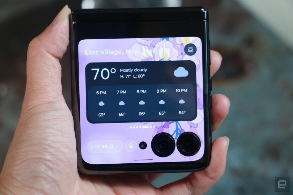 <p>The Motorola Razr+ folded shut and held in mid-air, with a weather widget showing on its external display.</p> 