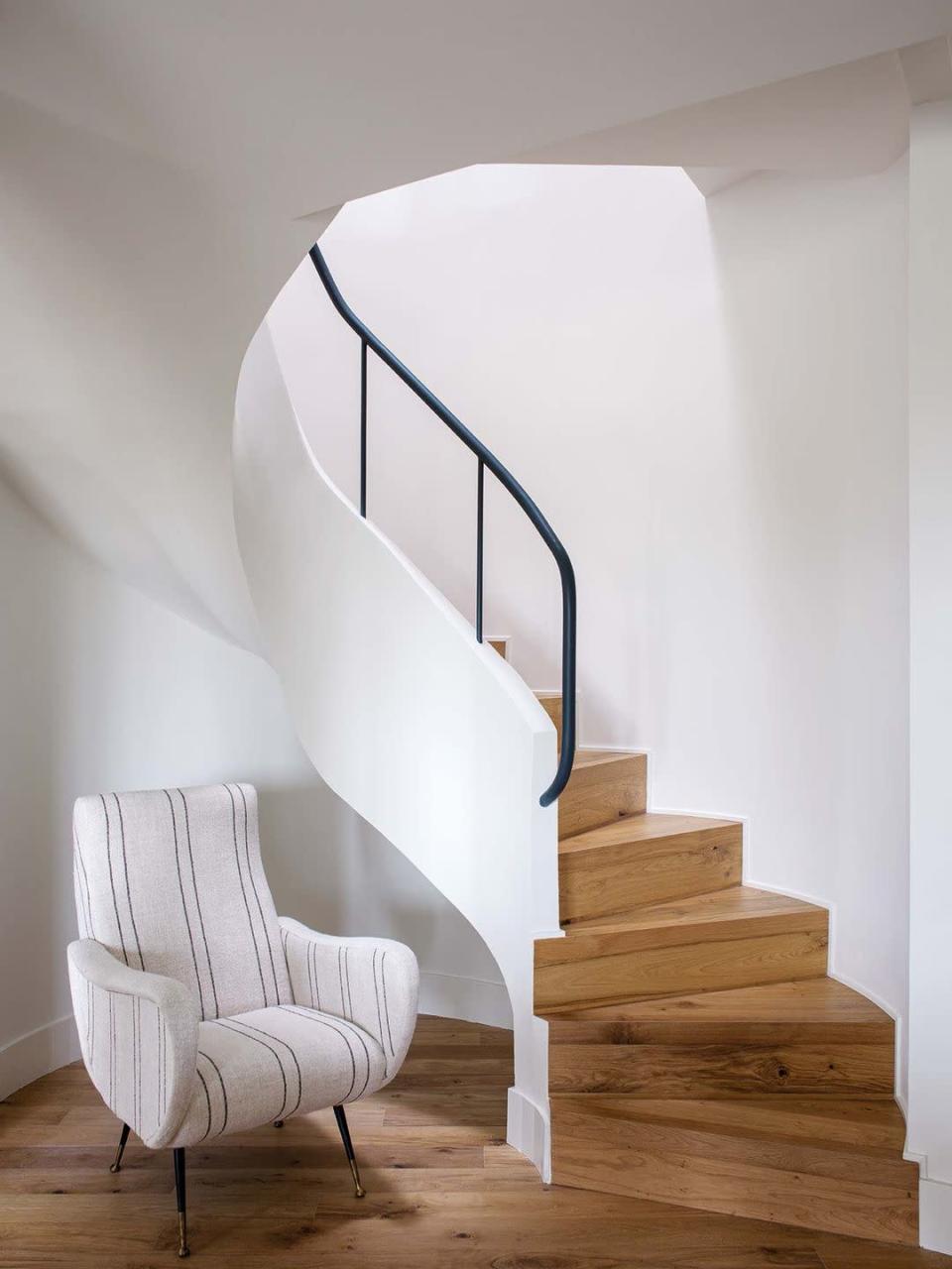 <p>El recibidor de esta vivienda está coronado por una bonita escalera de caracol con acabados blancos y de madera natural. Para equilibrar el espacio, una elegante butaca en los mismo tonos.</p><p>La casa completa, aquí: <a href="https://www.elledecor.com/es/casas/a36295544/casa-blanco-madera-luminosa-moderna-elegante/" rel="nofollow noopener" target="_blank" data-ylk="slk:Blanco y madera para crear una casa elegante y sencilla" class="link ">Blanco y madera para crear una casa elegante y sencilla</a>. </p>