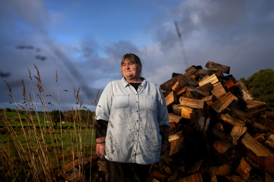 Carmall Casey stands for a portrait in her yard in Black River, Tasmania, Australia, Wednesday, July 24, 2019. From her home in rural northwest Tasmania, not far from the poppy fields that produce half the world's supply of the raw ingredients in pharmaceutical opiates, Casey seethes over a system she says pushed her and so many others into addiction. It is a system that has made opioids the cheap and easy alternative for so many Australians. (AP Photo/David Goldman)