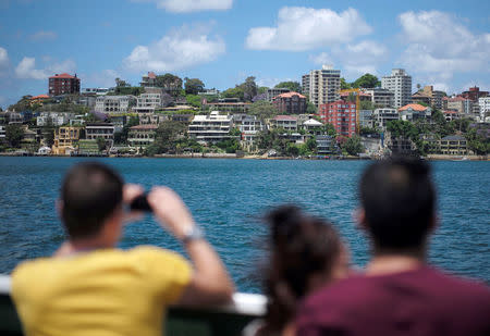 Passengers on a public ferry look and take photographs of homes located along the foreshore of Sydney Harbour in Australia, November 16, 2016. REUTERS/Jason Reed