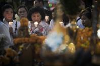 People hold a candlelight vigil to pay their respects to the people who died at Erawan shrine, the popular tourist site where 20 people were killed on August 17, marking one week since the attack in central Bangkok on August 24, 2015