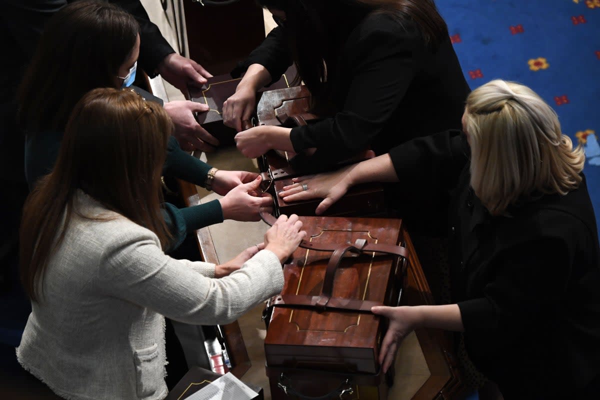 Cases containing electoral votes are opened during a joint session of Congress after the session resumed following protests at the US Capitol in Washington, DC, early on 7 January 2021 (AFP via Getty Images)