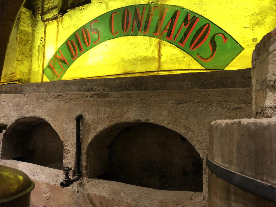 This historic distillery produced Herradura tequila from 1870 to 1963, when the facility’s modern operation was built next door. The words “En Dios Confiamos” emblazoned on the wall where workers once toiled to ferment and distill tequila mean “In God We Trust.” [Photo: Mary Ann Akers]