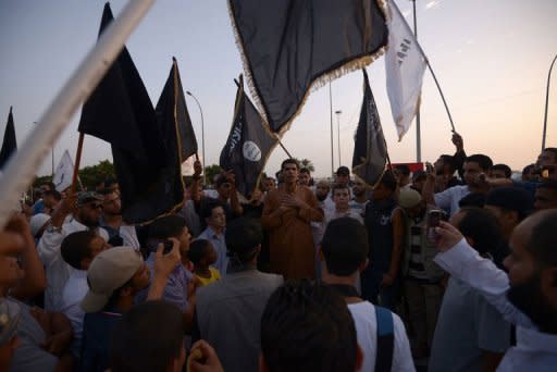 Supporters and members of hardline Islamist group of Ansar al-Sharia shout slogans as they wave Al-Qaeda affiliated flags during a demonstration against a film mocking Islam in Benghazi