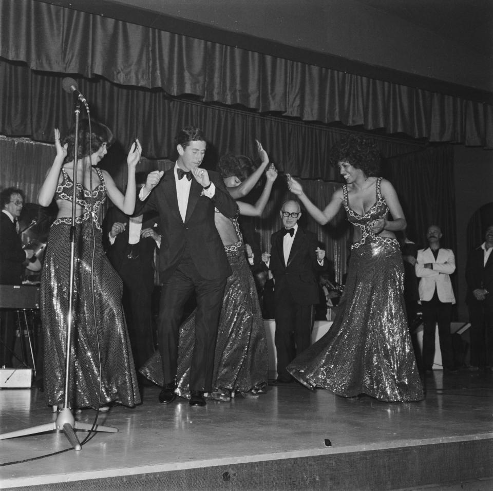 Prince Charles (later Charles III) takes the stage with American soul vocal group, The Three Degrees, during a charity fundraising event for the Prince's Trust at the King's Country Club in Eastbourne, East Sussex, July 1978. Left to right: Helen Scott, Prince Charles, Valerie Holiday and Sheila Ferguson. English entertainer Rod Hull (1935 - 1999) is behind the Prince (left). (Photo by Doug McKenzie/Hulton Archive/Getty Images)