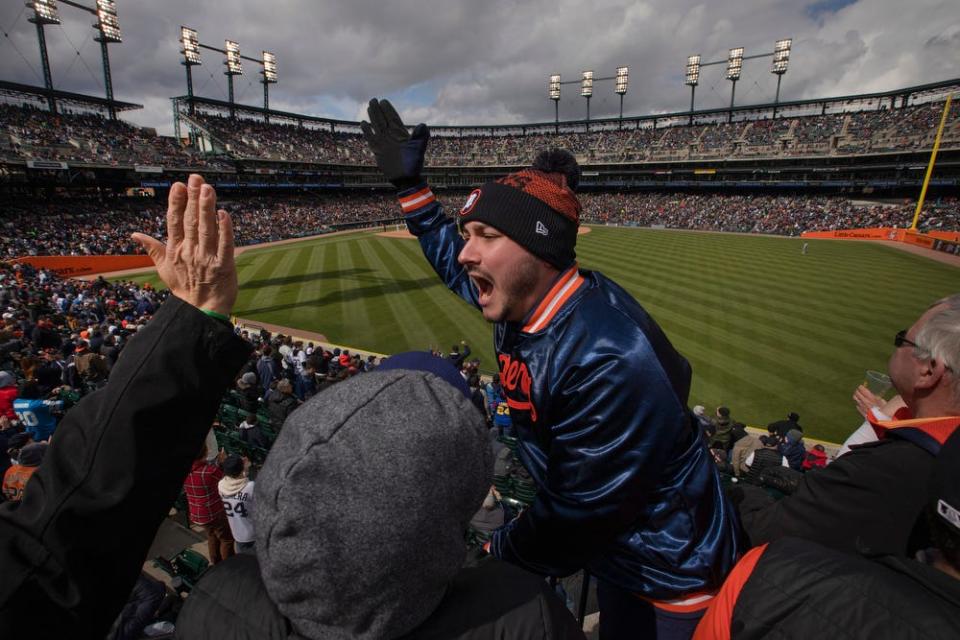 Sammy McLean, 29, of Windsor, Ontario celebrates with friends after the Detroit Tigers score a run on Opening Day at Comerica Park on Friday, April 8, 2022. The Tigers won 5-4 against the Chicago White Sox.
