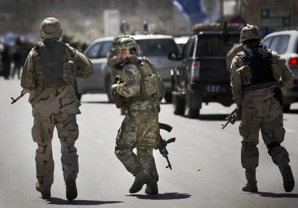 Afghan special forces arrive to the scene after the Taliban launched an assault with a suicide bomber detonating his vehicle outside an election office in Kabul, Afghanistan, Tuesday, March 25, 2014. Gunmen stormed into the building, trapping dozens of employees inside and killing many people. A candidate for a seat on a provincial council was among those killed, along with an election worker, a civilian and a policeman.(AP Photo/Anja Niedringhaus)