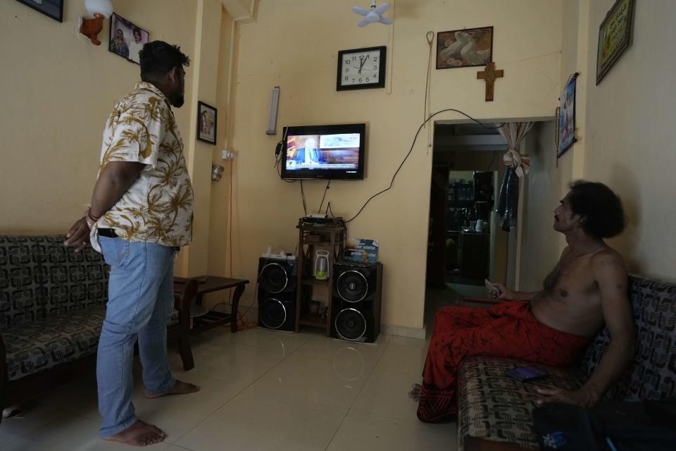 People watch on television Sri Lankan President Ranil Wickremesinghe speak on the IMF bail out package in Colombo, Sri Lanka, Tuesday, March 21, 2023. The International Monetary Fund said Monday that its executive board has approved a nearly $3 billion bailout program for Sri Lanka over four years to help salvage the country's bankrupt economy.(AP Photo/Eranga Jayawardena)