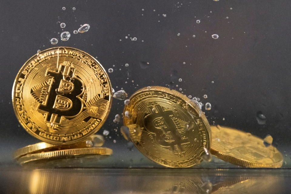 Souvenir tokens representing cryptocurrency Bitcoin plunge into water in this illustration taken May 17, 2022. REUTERS/Dado Ruvic/Illustration