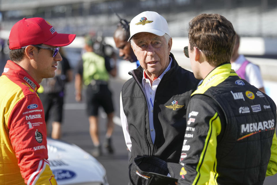 Roger Penske, center, speaks with drivers Joey Logano, left, and Ryan Blaney before practice for the NASCAR auto race at Indianapolis Motor Speedway, Saturday, July 30, 2022, in Indianapolis. (AP Photo/AJ Mast)