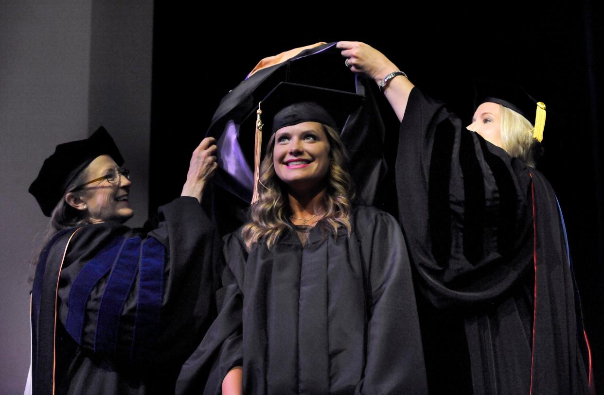 Haley Katherine Humphrey smiles as Nancy Kucinski (left) and Jennifer Plantier hang her ceremonial hood around her neck during commencement May 13, 2017, at Hardin-Simmons University. Humphrey received a master of business administration degree.