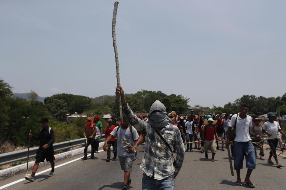 Después de que los agentes de inmigración mexicanos detuvieron a algunos migrantes centroamericanos en la carretera, otros migrantes del grupo se hacen de palos y piedras para defenderse mientras continúan su viaje a Pijijiapan, México, el lunes 22 de abril de 2019. La policía mexicana y los agentes de inmigración detuvieron a centenares de migrantes el lunes en la mayor redada registrada en una caravana de migrantes desde que los grupos comenzaron a moverse a través de México el año pasado. (AP Foto/Moisés Castillo)