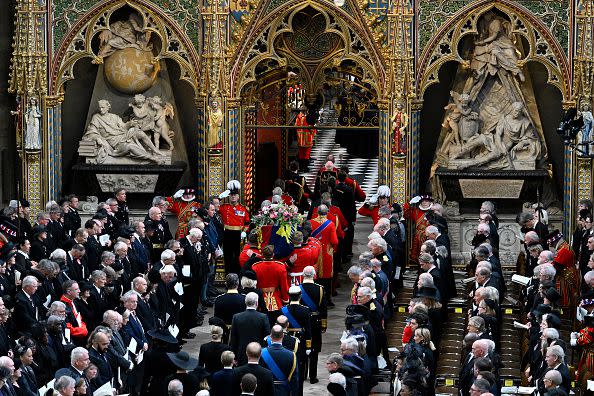 LONDON, ENGLAND - SEPTEMBER 19: The coffin of Queen Elizabeth II with the Imperial State Crown resting on top is carried by the Bearer Party into Westminster Abbey during the State Funeral of Queen Elizabeth II on September 19, 2022 in London, England. Elizabeth Alexandra Mary Windsor was born in Bruton Street, Mayfair, London on 21 April 1926. She married Prince Philip in 1947 and ascended the throne of the United Kingdom and Commonwealth on 6 February 1952 after the death of her Father, King George VI. Queen Elizabeth II died at Balmoral Castle in Scotland on September 8, 2022, and is succeeded by her eldest son, King Charles III.  (Photo by Gareth Cattermole/Getty Images)