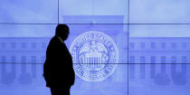 A security guard walks in front of an image of the Federal Reserve in Washington, DC, U.S., March 16, 2016. REUTERS/Kevin Lamarque/Files