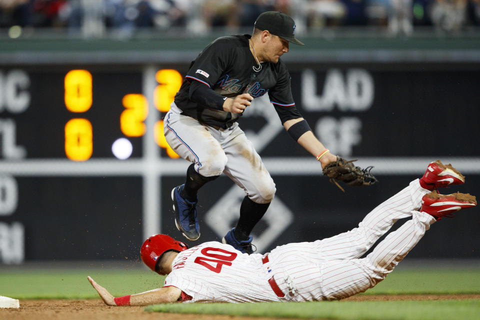 Philadelphia Phillies' Adam Haseley, bottom, slides into second base past Miami Marlins shortstop Miguel Rojas to advance on a wild pitch by starting pitcher Pablo Lopez during the fourth inning of a baseball game, Friday, Sept. 27, 2019, in Philadelphia. (AP Photo/Matt Slocum)