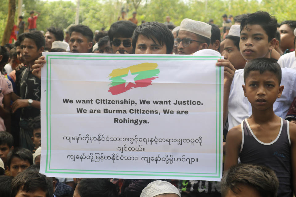 FILE- A Rohingya refugee holds a placard during a gathering to mark the fifth anniversary of their exodus from Myanmar to Bangladesh, at a Kutupalong Rohingya refugee camp at Ukhiya in Cox's Bazar district, Bangladesh, Thursday, Aug. 25, 2022. The United Nations and other groups urged countries in southern Asia on Friday to rescue as many as 190 people believed to be Rohingya refugees aboard a small boat that has been adrift for several weeks in the Andaman Sea. (AP Photo/ Shafiqur Rahman, File)