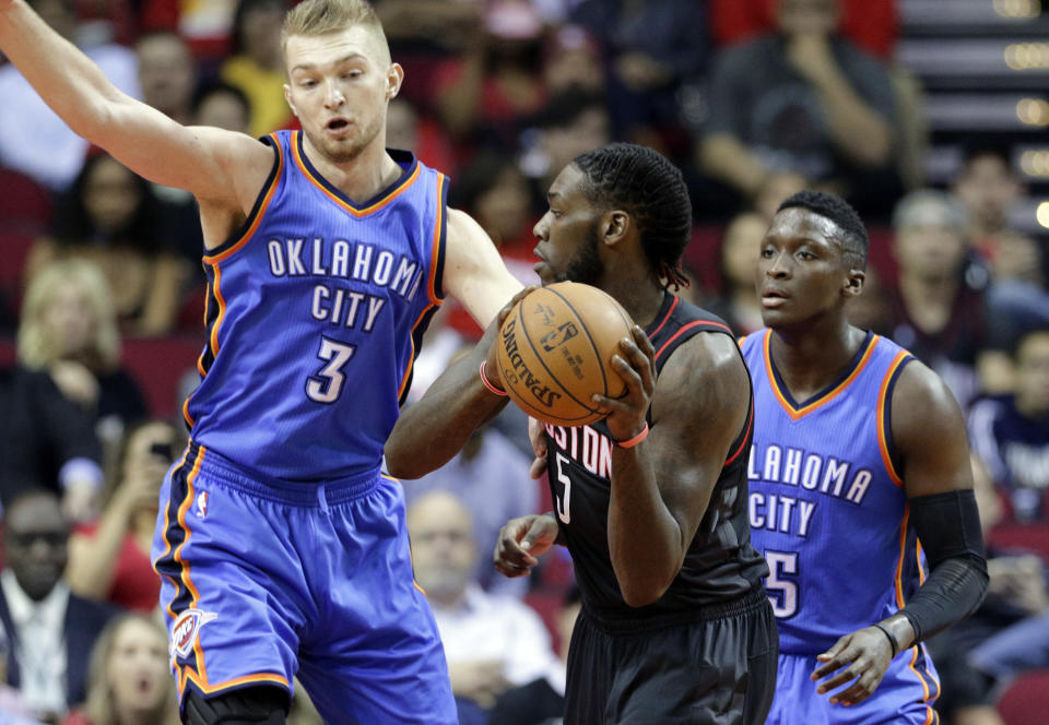 Oklahoma City Thunder's Domantas Sabonis (3) defends against the pass by Houston Rockets' Montrezl Harrell as Victor Oladip (5) looks on in the first quarter of an NBA basketball game in Houston, Thursday, Jan. 5, 2017. (AP Photo/Michael Wyke)