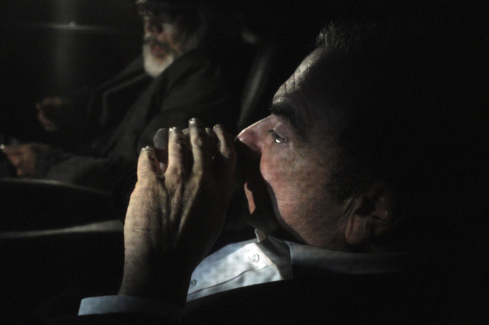 Former Nissan chairman Carlos Ghosn, front, travels in a car Wednesday, March 6, 2019, in Tokyo, after posting 1 billion yen ($8.9 million) in bail once an appeal by prosecutors against his release was rejected. Ghosn was arrested in November and is charged with falsifying financial reports and breach of trust. (AP Photo/Eugene Hoshiko)