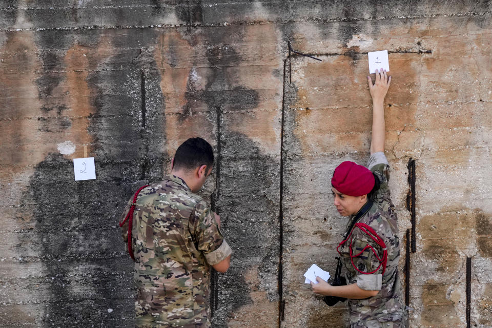 Lebanese Army investigators inspect bullet holes and collect forensic evidence next to the entrance of U.S. Embassy in Aukar, a northern suburb of Beirut, Lebanon, Thursday, Sept. 21, 2023. Lebanon's security agencies have launched an investigation into a late night shooting outside the U.S. embassy in Lebanon that caused no injuries, officials said Thursday. (AP Photo/Hassan Ammar)