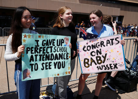 Girls hold posters during a visit by Britain's Prince Harry and wife Meghan, Duchess of Sussex at the Sydney Opera House in Sydney, Australia October 16, 2018. REUTERS/Phil Noble