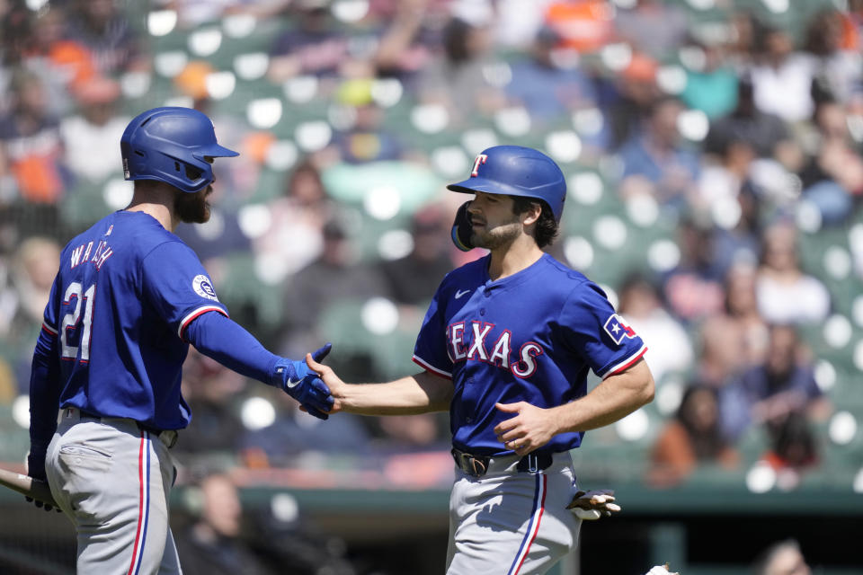 Texas Rangers' Josh Smith is greeted by Jared Walsh (21) after scoring from third on a single by designated hittere Ezequiel Duran during the fifth inning of a baseball game against the Detroit Tigers, Tuesday, April 16, 2024, in Detroit. (AP Photo/Carlos Osorio)
