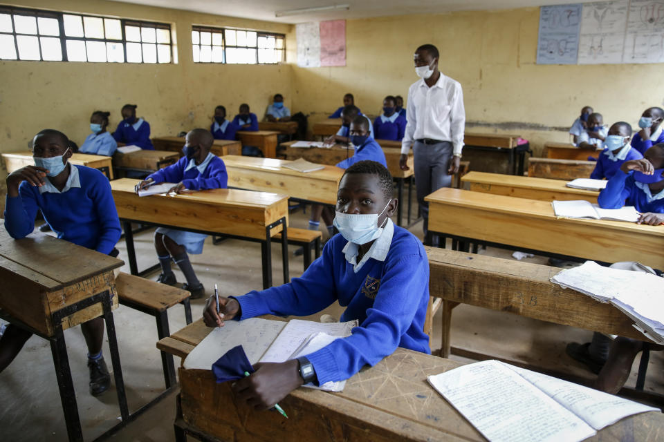 FILE - In this Monday, Oct. 12, 2020 file photo, schoolchildren attend class at the Olympic Primary School in Kibera, one of the capital Nairobi's poorest areas, as schools partially re-opened to allow those students due for examinations which had been postponed to prepare, in Kenya. As schools reopen in some African countries after months of lockdown, relief is matched by anxiety over everything from how to raise tuition fees amid the financial strain wrought by the COVID-19 pandemic to how to protect students in crowded classrooms. (AP Photo/Brian Inganga, File)