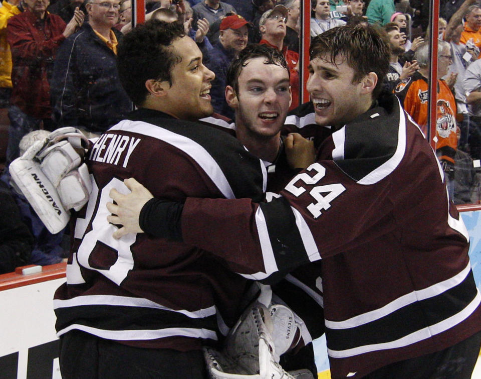 Union's Colin Stevens, center, reacts to a win with teammate Noah Henry, left, and Sebastien Gingras, right, during the third period of an NCAA men's college hockey Frozen Four tournament game against Minnesota, Saturday, April 12, 2014, in Philadelphia. Union won 7-4. (AP Photo/Chris Szagola)