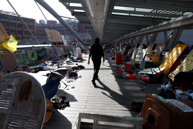 One of the last remaining protesters walk through an abandoned barricade that was a frontline, at the Hong Kong Polytechnic University (PolyU)