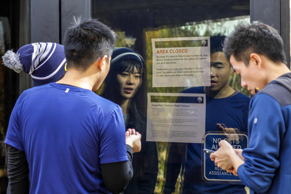 Visitors read a closure notice on the doors of Joshua Tree National Park Visitor Center. The park was open, but its visitors center was closed due to the government shutdown, Dec. 22, 2018. (Photo: Irfan Khan/Los Angeles Times via Getty Images)