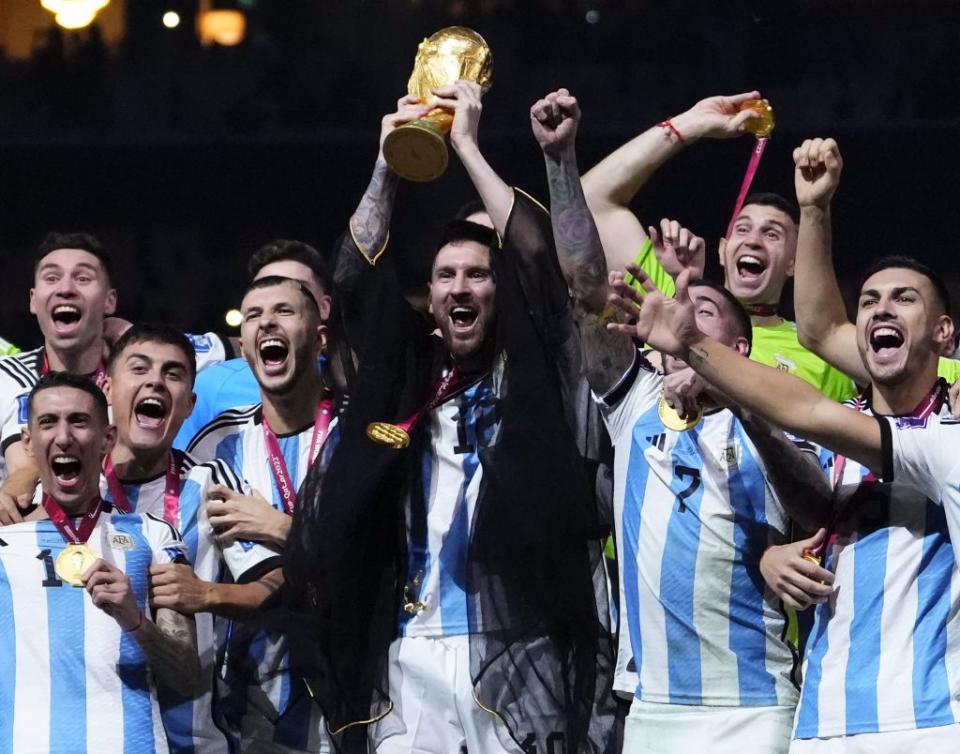 阿根廷隊長梅西高舉世足冠軍盃。（美聯社）