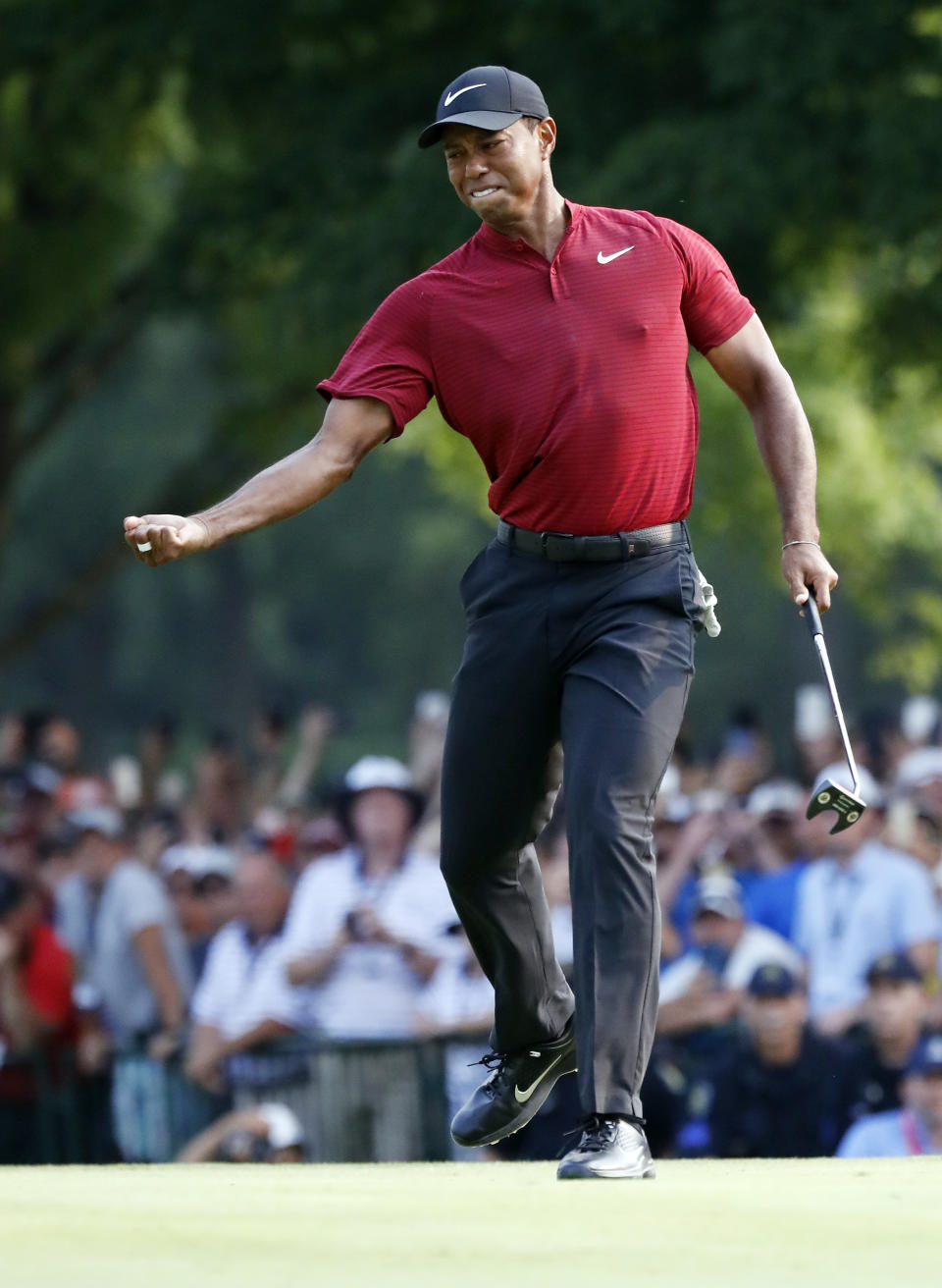 Tiger Woods celebrates after making a birdie putt on the 18th green during the final round of the PGA Championship golf tournament at Bellerive Country Club, Sunday, Aug. 12, 2018, in St. Louis. (AP Photo/Brynn Anderson)