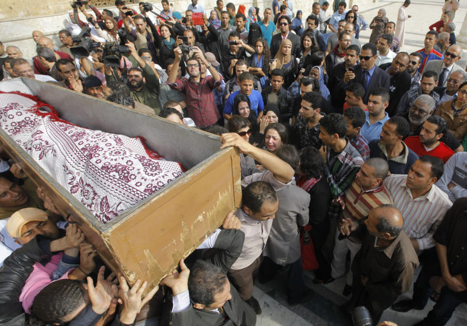Egyptians carry the coffin of Egypt’s best known satirical poet, Ahmed Fouad Negm, following funeral prayers at al-Hussein mosque in Cairo, Egypt, Tuesday, Dec. 3, 2013. Known as the "poet of the people," Negm's use of colloquial Egyptian Arabic endeared him to his countrymen who saw in his verse an unvarnished reflection of how they felt about milestones in their nation's history like the humiliating defeat at the hands of Israel in 1967, the 1979 peace treaty with Israel and the authoritarian rule of Hosni Mubarak. (AP Photo/Amr Nabil)