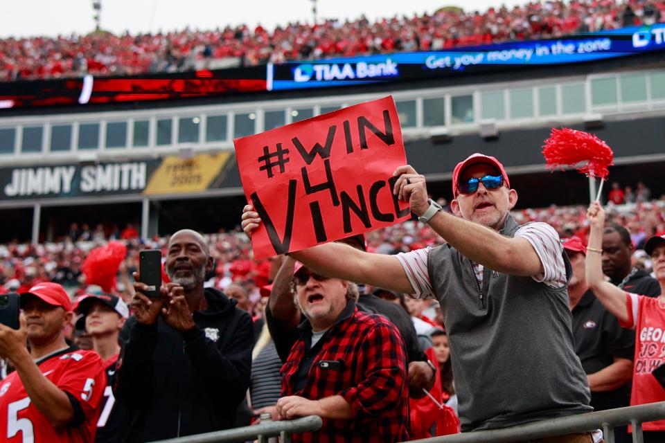 A fan holds up a sign honoring Vince Dooley, former Georgia Bulldogs head football coach and athletic director, during the first quarter of an NCAA football game Saturday, Oct. 29, 2022 at TIAA Bank Field in Jacksonville. The Georgia Bulldogs outlasted the Florida Gators 42-20. [Corey Perrine/Florida Times-Union]