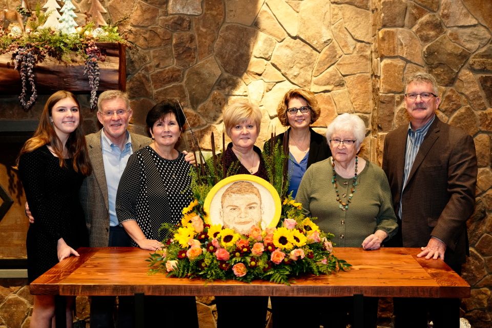 Smith-McCracken Funeral Home and the NJ Sharing Network paid tribute to Tyler Rodimer by decorating a floragraph that will be featured on the Donate Life float at the 134th annual Rose Parade on Jan. 2, 2023. The floragraph, a portrait of Rodimer made of floral and other natural materials, was completed at the Hudson Farm Club in Hopatcong on Friday, Dec. 2, 2022. From left are Rodimer's family: Kaite Hosko; Dr. Robert Hosko, his grandfather; Karen Hosko; Lorie Rodimer, Tyler's mother; Tracy Hosko; Sallie Hosko, his maternal grandmother, and Ronald Hosko.