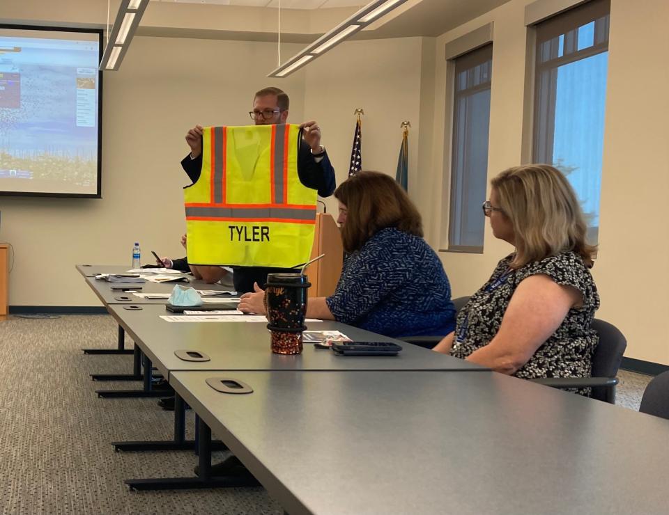 Michael McFarlane, an Tyler Technologies official overseeing the property tax reassessment effort, displays the vests surveyors are to wear when they visit homes and businesses as part of the process.