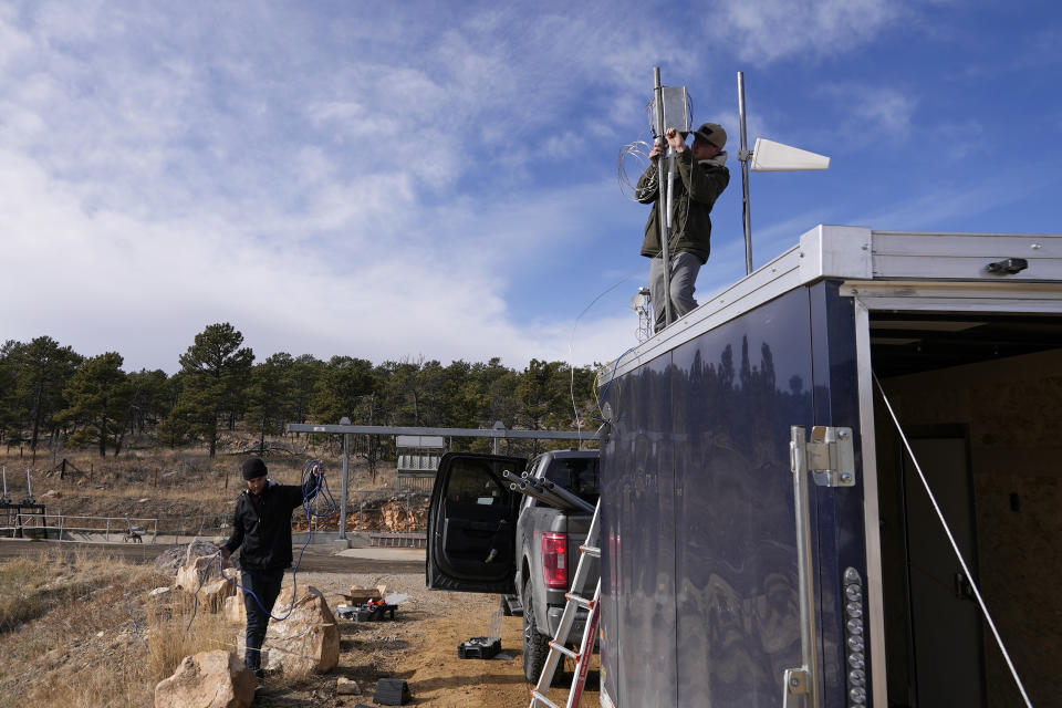 Brothers Parker and Carver Cammans install cloud seeding equipment Saturday, Dec. 3, 2022, in Lyons, Colo. The Southern Nevada Water Authority on Thursday, March 16, 2023, voted to accept a $2.4 million grant from the U.S. Bureau of Reclamation to fund cloud seeding in other Western states whose rivers feed the parched desert region. The weather modification method uses planes and ground-based cannons to shoot silver iodide crystals into clouds, attracting moisture to the particles that falls as additional snow and rain. (AP Photo/Brittany Peterson)