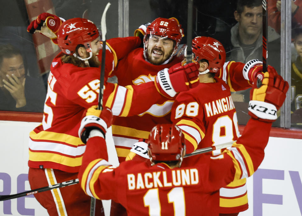 Calgary Flames defenseman MacKenzie Weegar, center, celebrates his goal with teammates in overtime of an NHL hockey game against the Vegas Golden Knights in Calgary, Alberta, Monday, Nov. 27, 2023. (Jeff McIntosh/The Canadian Press via AP)