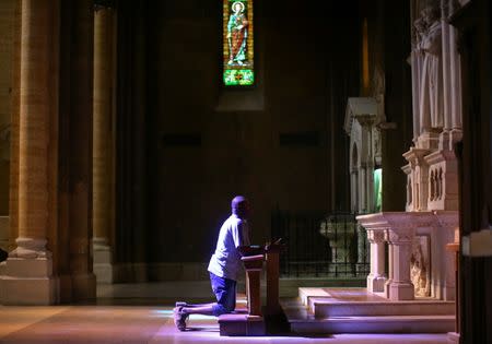 Nigerian Charles Otokiti, 37, who was rescued at sea after passing through Libya in 2016, prays in a church in Rome, Italy, July 5, 2018. Picture taken July 5, 2018. REUTERS/Alessandro Bianchi