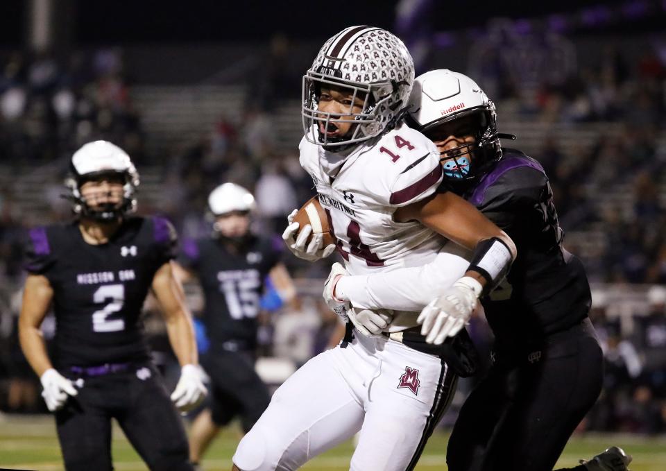 Mt. Whitney's Israel Briggs tires to shake loose against a Mission Oak defender during their Central Section Division III high school quarterfinal football game in Tulare, Calif, Thursday, Nov. 9, 2023.