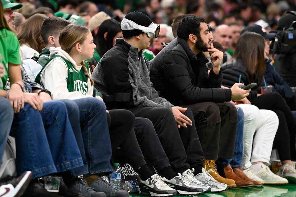 A spectator watches the court while wearing Apple Vision goggles during the second half of a game between the Memphis Grizzlies and the Boston Celtics in Boston, Massachusetts.