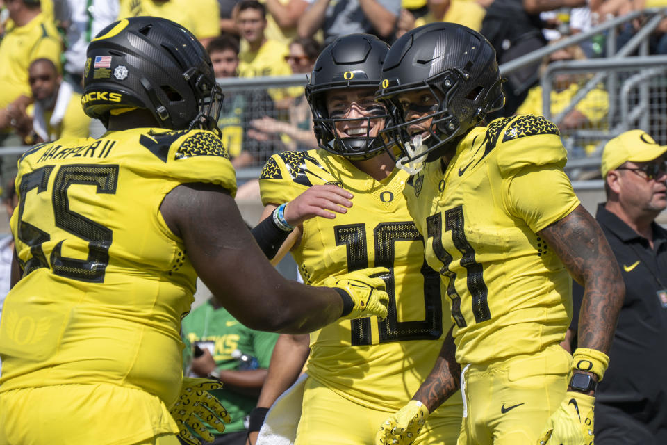 Oregon quarterback Bo Nix (10) celebrates with wide receiver Troy Franklin (11) and offensive lineman Marcus Harper II after Franklin's touchdown during the first half of an NCAA college football game Saturday, Sept. 2, 2023, in Eugene, Ore. (AP Photo/Andy Nelson)