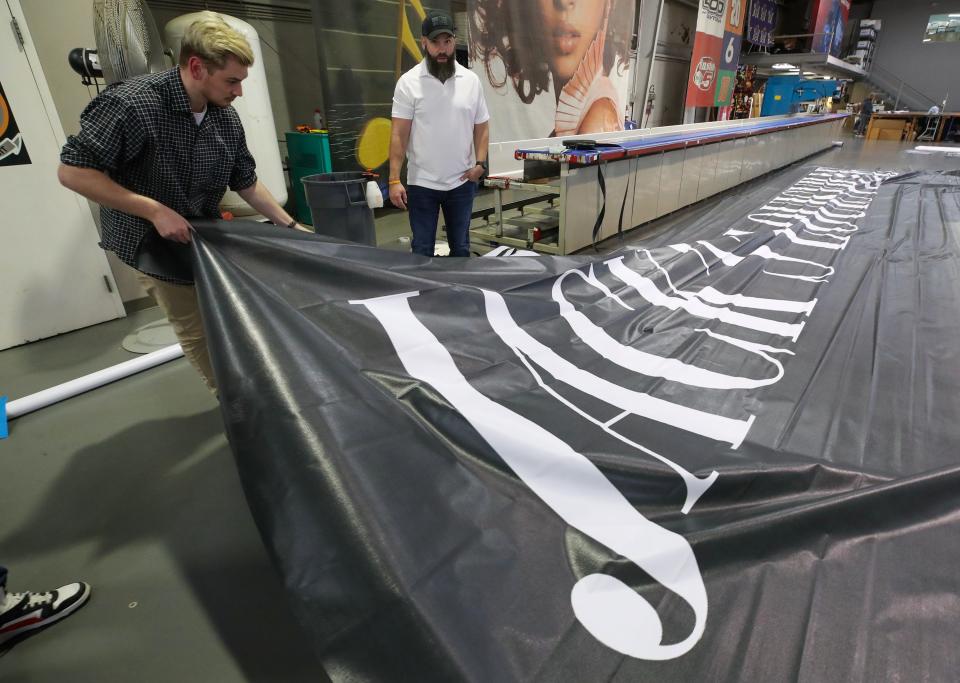 The staff at USA Image prepares the Hometown Hero banner of Jack Harlow at their facility in Jeffersontown.  The banner measures 45 feet by 70 feet.